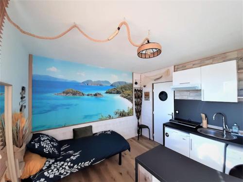 une chambre avec une cuisine et une chambre avec un tableau dans l'établissement Songe Tropical-InvIRI. Studio CHU. Parking Aisé., à Limoges