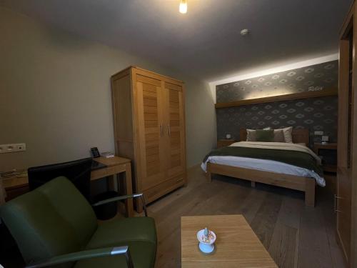 a bedroom with a bed and a couch and a table at B&B Het KoeKoeKsnest Schelle in Schelle