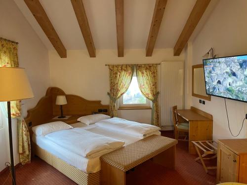 a bedroom with a bed and a flat screen tv at Wellness e Resort Stella Delle Alpi in Ronzone