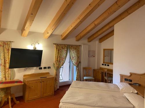 a bedroom with a bed and a flat screen tv at Wellness e Resort Stella Delle Alpi in Ronzone