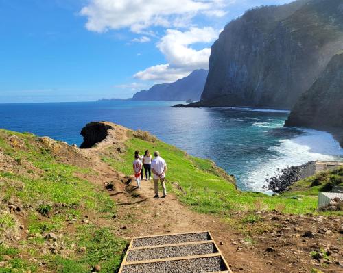 three people walking down a path near the ocean at Sleep and Go in Santana in Nature B&B in Santana