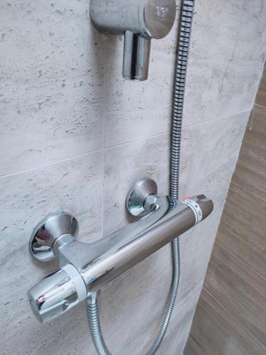 a shower door with a metal handle on a wall at Francigena Viterbo Apartment con parcheggio gratuito a soli 2 minuti in Viterbo