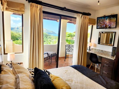 1 dormitorio con cama y ventana grande con vistas en Amazing Oceanview rooftop terrace walk to beach, en Coco
