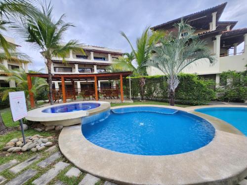 a large swimming pool in front of a building at Amazing Oceanview rooftop terrace walk to beach in Coco