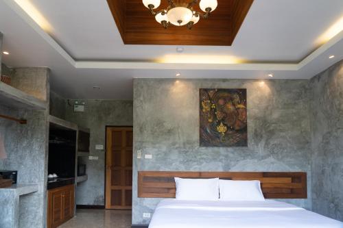 Anodard Phuket, Nai Yang Beach في تالانغ: غرفة نوم بسرير ودهان على الحائط