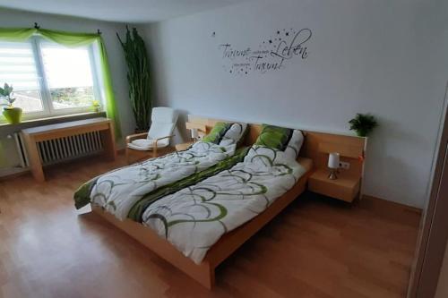 ein Schlafzimmer mit einem Bett, einem Stuhl und einem Fenster in der Unterkunft Ferienwohnung Dürr in Gaukönigshofen