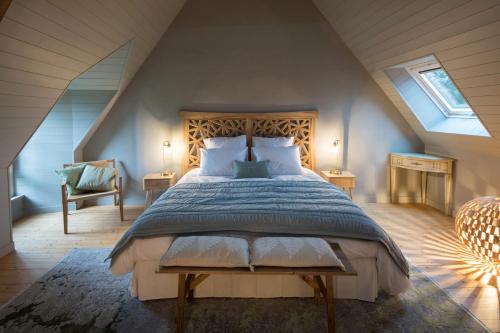 ein Schlafzimmer mit einem großen Bett im Dachgeschoss in der Unterkunft MANOIR DU VAU D ARZ gîtes et chambres d hôtes avec piscine in Malansac