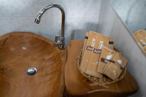 a wooden toilet with a faucet and boxes on it at Anodard Phuket, Nai Yang Beach in Thalang