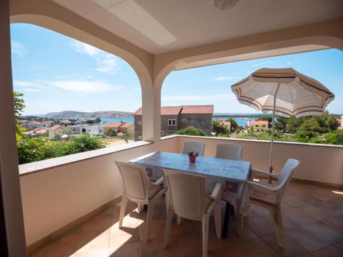 a balcony with a table and chairs and an umbrella at Apartments Đoković in Rab