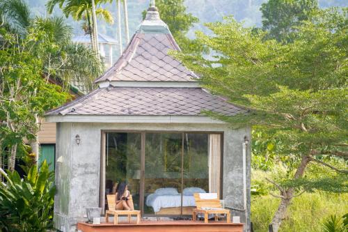 a small cottage with a bed and a window at Anodard Phuket, Nai Yang Beach in Thalang