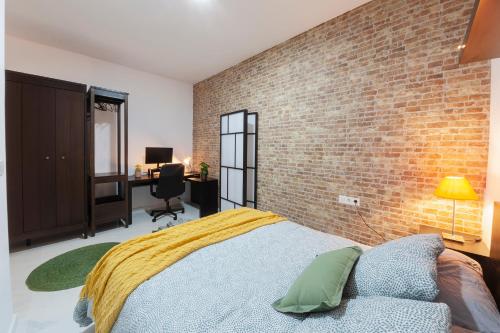 a bedroom with a brick wall and a bed at Artistic Digital Retreat-Great Location Near Metro in Valencia