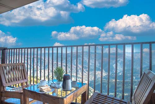 a table on a balcony with a view of the ocean at The Tikker in Shimla