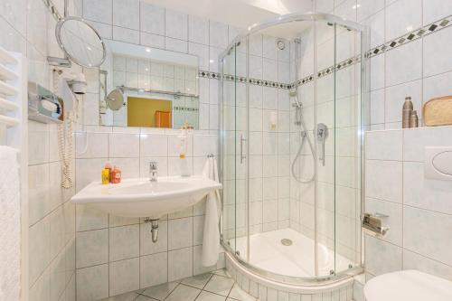 a bathroom with a sink and a shower at Lohmann's Kapeller Hof in Langenfeld