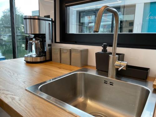 a kitchen sink with a coffee maker next to a window at La Mare Resort in Gothenburg