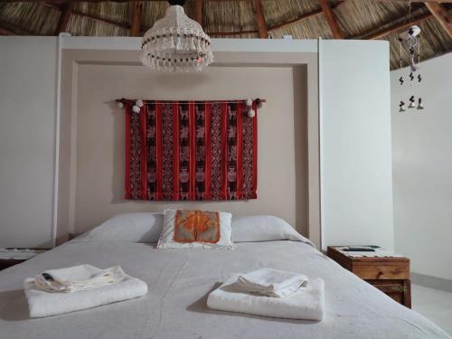 巴拉德羅的住宿－Tierra de Inmigrantes，一间卧室配有一张床,上面有两条毛巾