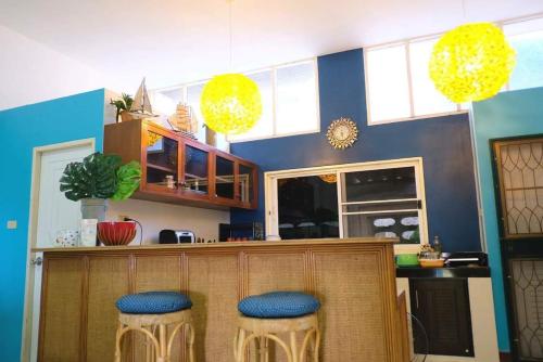 een bar met blauwe en gele krukken in een kamer bij In Talay in Cha Am