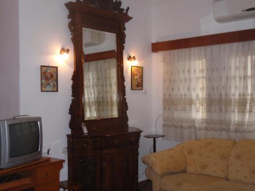uma sala de estar com um sofá e uma televisão em Traditional city house em Kalymnos