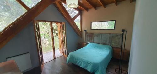 1 dormitorio con 1 cama azul en el ático en Ayres Pampa III en Balneario Mar Azul