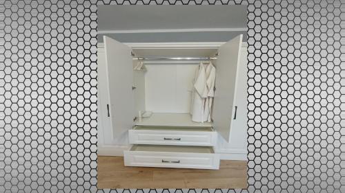 łazienka z dużym lustrem i białą szafą w obiekcie Vi’studio w Sybinie