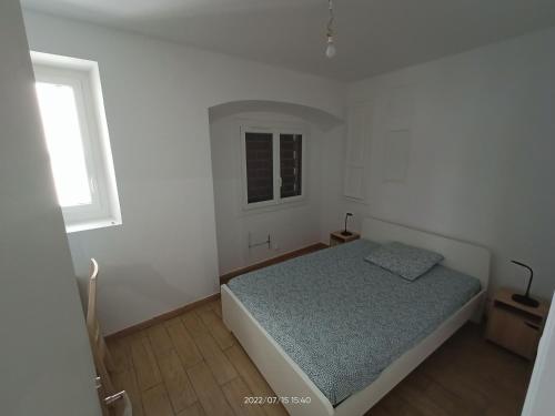 een witte slaapkamer met een bed en een raam bij T2 rénové en RDC avec cour, Intra Muros Avignon in Avignon