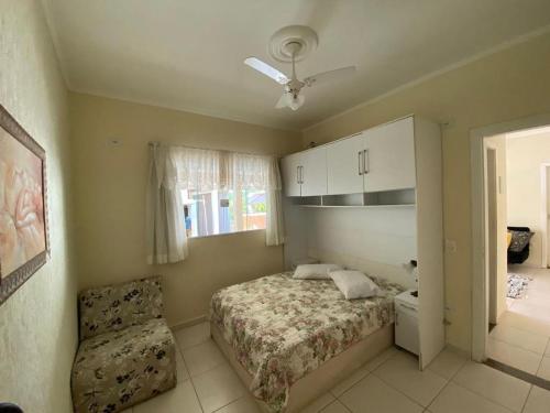 ein Schlafzimmer mit einem Bett und einem Stuhl darin in der Unterkunft Casa Águas de São Pedro in Águas de São Pedro