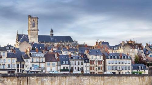 a group of buildings with a city in the background at Studio avec parking face a la gare in Nevers