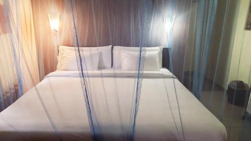 a bed with white sheets and pillows in a room at Sitha's Heaven in Ella