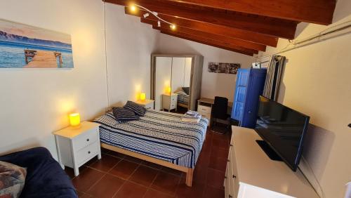 a small room with a bed and a television at Casa Marcos in La Gomera with relaxing terrace in Agulo