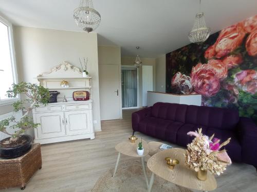 salon z fioletową kanapą i stołami w obiekcie Appart proche centre- gare-stade-hôpital- Prisme-Belle vue w mieście Aurillac