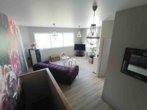 a living room with two purple couches and a table at Appart proche centre- gare-stade-hôpital- Prisme-Belle vue in Aurillac