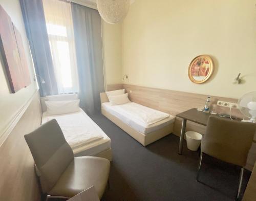 a small room with two beds and a table at Hotel Central in Bamberg