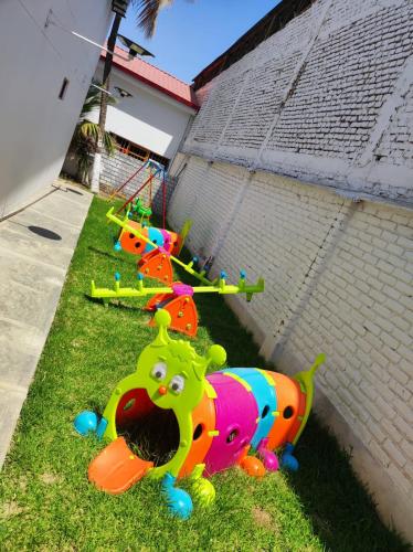 a row of childrens play equipment on the grass at Hotel El Bosque in Jaén