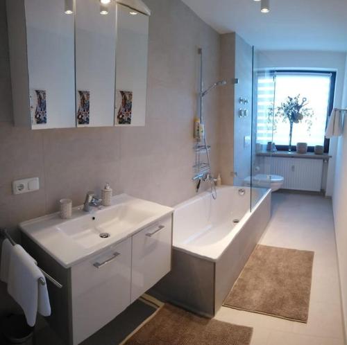 bagno con 2 lavandini, vasca e doccia di Wohnung direkt am Tegernsee mit XL-Terrasse a Gmund am Tegernsee