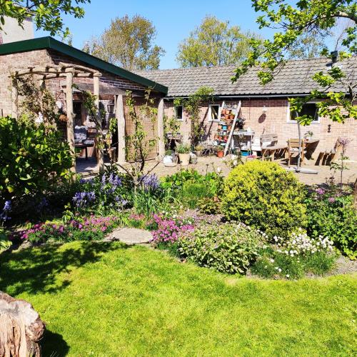 a garden in front of a house with flowers at Vakantiewoning De Koolboet in Koedijk