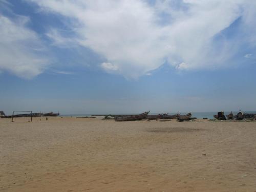 a group of boats sitting on a sandy beach at KEUR DIAM - Maison de la Paix in Saly Portudal