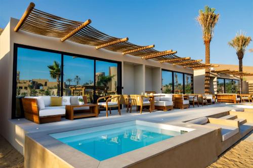 an outdoor patio with a pool and tables and chairs at Terra Solis Dubai in Dubai