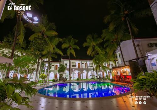 a swimming pool in front of a building at night at Hotel El Bosque in Jaén