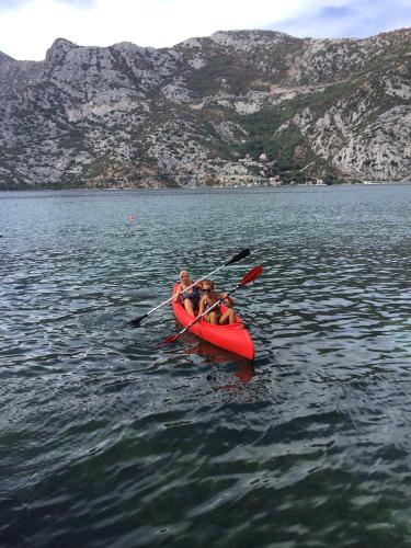 two people in a red kayak on a body of water at Apartments Subotic in Risan