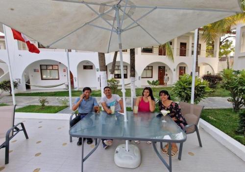 a group of people sitting at a table under an umbrella at Hotel El Bosque in Jaén