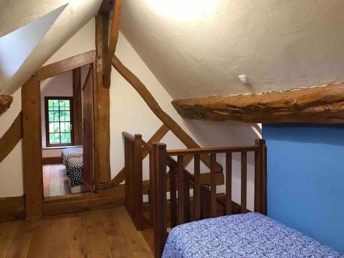 1 dormitorio con escalera y 1 cama en una habitación en La Laiterie Normande, 