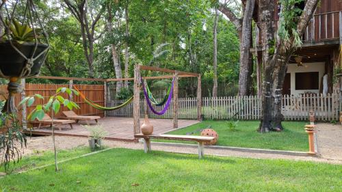 a playground with a swing and a hammock in a yard at Casa Saimiri in Alter do Chao