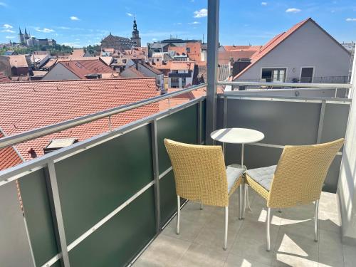 a balcony with two chairs and a table with a view at Hotel Central in Bamberg