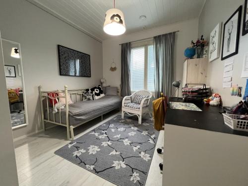 um pequeno quarto com um berço e um sofá em Ski Villa Serena em Pyhäjoki