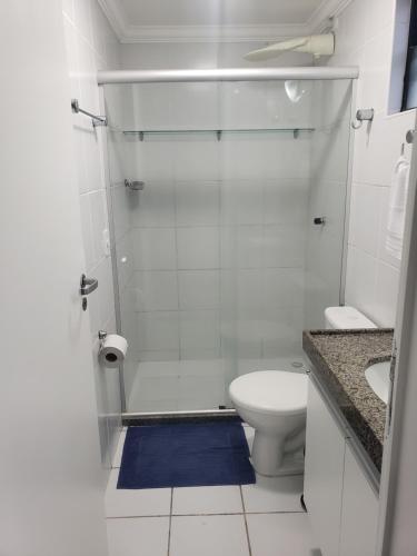 uma casa de banho com um chuveiro, um WC e um tapete azul em Apt 2 QUARTOS, 2 WC, POINT DA JATIÚCA ACOMODA 9 em Maceió