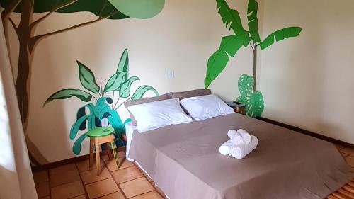 1 dormitorio con 1 cama con un árbol pintado en la pared en Casa Saimiri en Alter do Chao