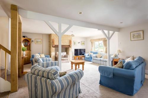 a living room with blue chairs and a couch at Stanway House, 8 bedroom, 8 Bath in Cheltenham