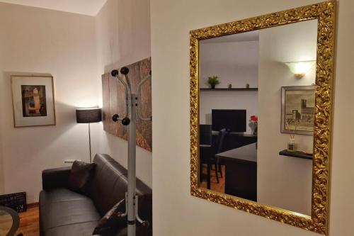 a living room with a couch and a mirror at Arezzo Charming Apartment in Arezzo