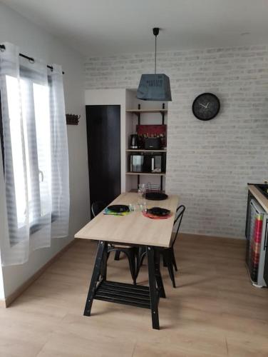 une table avec deux chaises dans une pièce dans l'établissement L'Atelier de l'Artiste - Moulins Cœur de ville, à Moulins