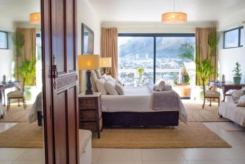 ein Schlafzimmer mit großem Bett und großem Fenster in der Unterkunft Radium Hall Guest House in Kapstadt
