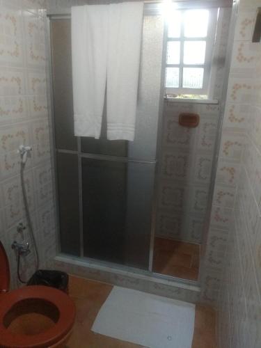 a bathroom with a shower with a toilet and a window at Nova Pousada Chamonix in Teresópolis